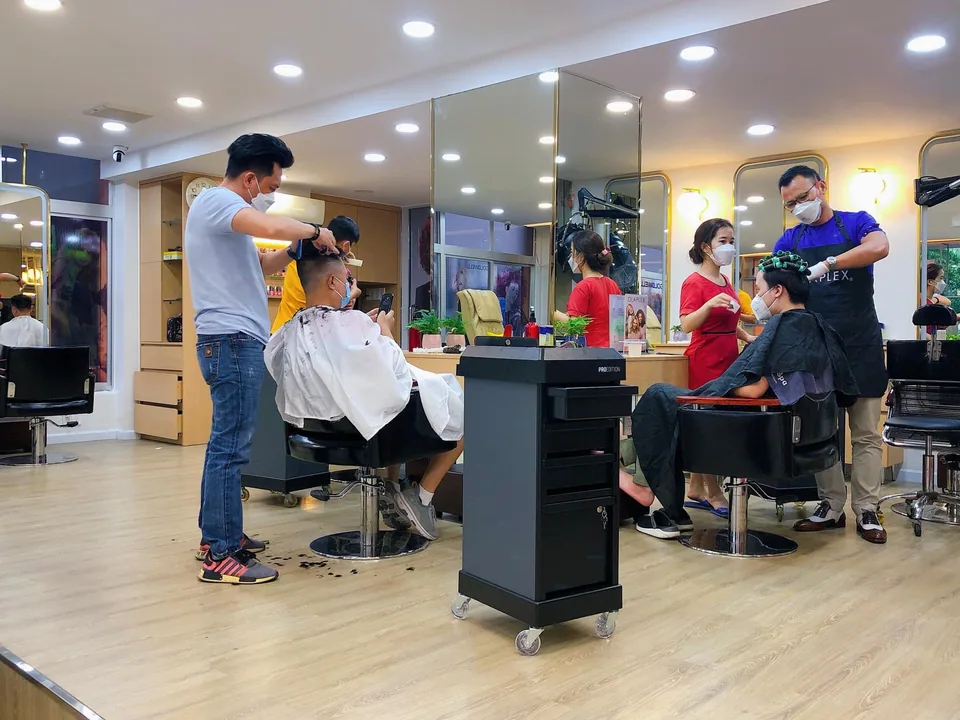 Không gian phòng trị liệu của Happy Spa với ánh đèn ấm và giường massage trải khăn trắng.
